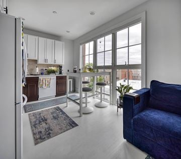 Philadelphia apartment for rent - A blue couch is in the living room with a kitchen in the background.
