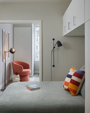 Philadelphia apartment for rent - A snapshot of the bedroom area in LVL West 1-Bedroom floorplan. Camera is looking out from the bedroom into the living room, where the reading nook with armchair are visible.