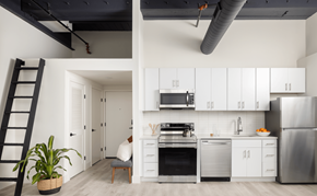 Philadelphia apartment for rent - a kitchen with white cabinets and stainless steel appliances and a black staircase
