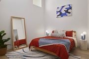 Philadelphia apartment for rent - A bedroom with a red bedspread and a blue and white abstract painting on the wall. at 1600 Callowhill, Philadelphia, PA