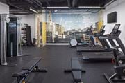 Philadelphia apartment for rent - A gym with treadmills, weights, and a city view mural on the wall.at 1600 Callowhill, Philadelphia, PA