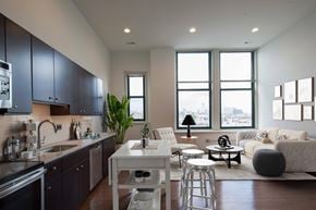 Philadelphia apartment for rent - A modern kitchen with dark grey cabinets and a white island.