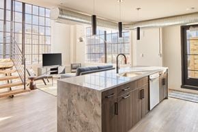 Philadelphia apartment for rent - a kitchen with an island and a living room with a couch and a tv