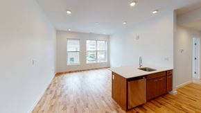 Cincinnati apartment for rent - an empty living room and kitchen with wood flooring and a sink