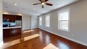 Cincinnati apartment for rent - an empty living room with a ceiling fan and a kitchen