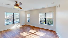 Cincinnati apartment for rent - A room with a ceiling fan and wooden flooring.