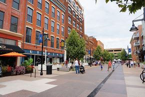 Fort Wayne apartment for rent - A city street with people walking and a red umbrella.