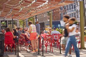 Cincinnati apartment for rent - A busy outdoor restaurant with people sitting at tables and enjoying their meals.