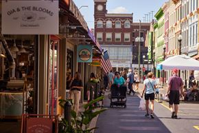 Cincinnati apartment for rent - A street scene with people walking and a sign that says "MOTHER'S DAY".