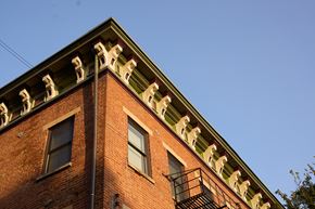 Cincinnati apartment for rent - A red brick building with a green roof and white decorative elements.