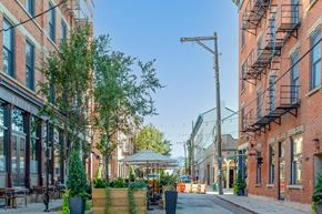 Cincinnati apartment for rent - a city street with brick buildings and a gazebo on the sidewalk