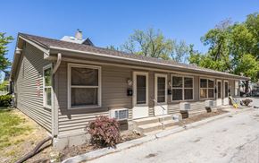 Des Moines apartment for rent - A house with a grey siding and a brown roof with a chimney.
