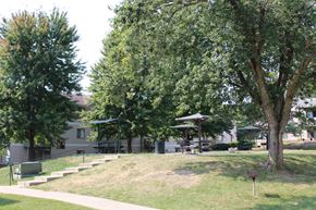 Des Moines apartment for rent - a grassy area with trees and buildings in the background