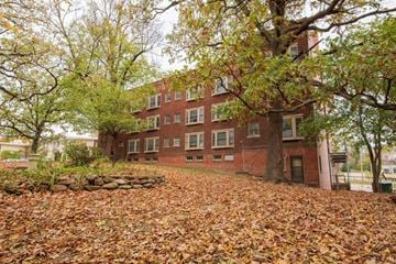 Des Moines apartment for rent - A large tree with yellow leaves in front of a red brick building.