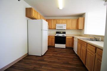 Pleasant Hill apartment for rent - a kitchen with wooden cabinets and a white refrigerator