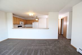 Waukee apartment for rent - an empty living room with a kitchen in the background