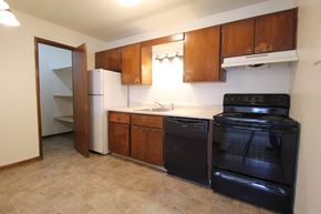 Urbandale apartment for rent - a kitchen with wooden cabinets and black appliances