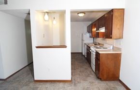 Urbandale apartment for rent - a kitchen with white walls and brown cabinets