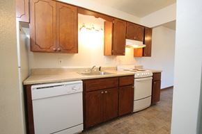 Urbandale apartment for rent - a kitchen with wooden cabinets and white appliances