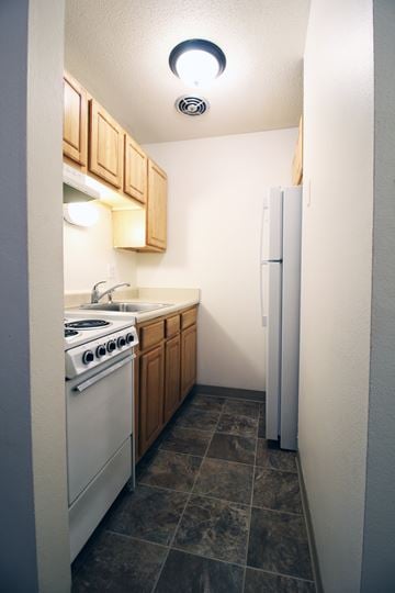 Des Moines apartment for rent - A small kitchen with a white stove and a white refrigerator.