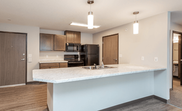 Des Moines apartment for rent - A kitchen with a marble countertop and wooden cabinets.