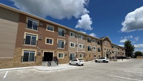 Marshalltown apartment for rent - a large brick apartment building with cars parked outside