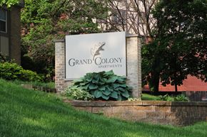 Des Moines apartment for rent - A sign for Grand Colony Apartments is displayed in front of a building.
