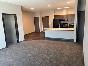 Marshalltown apartment for rent - an empty living room with a kitchen and a door to a closet