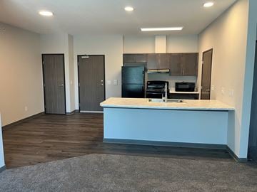Marshalltown apartment for rent - a kitchen and living room with a blue island and a black refrigerator