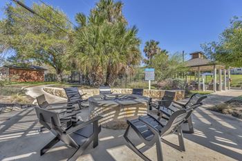 A group of chairs around a patio with a fire pit