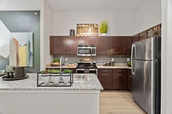Modern kitchen with island and stainless steel refrigerator