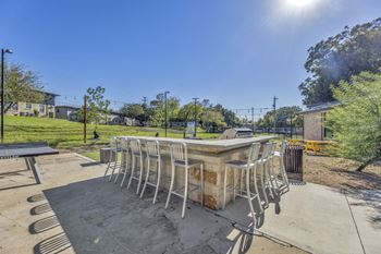 A patio with a bar and chairs around it
