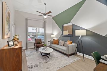 San Antonio apartment for rent - A living room with a white couch and a ceiling fan.