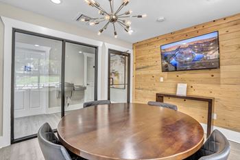 A conference room with a large table and a tv on the wall