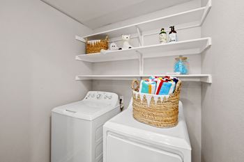 Laundry room with washer dryer and storage shelving