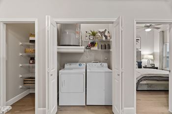 Laundry closet with washer dryer and storage shelving