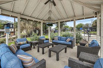 A covered patio with couches and tables
