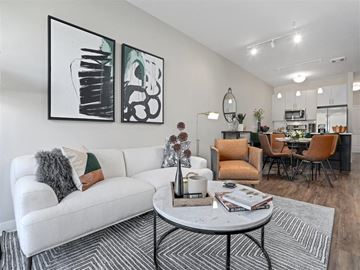 Ann Arbor apartment for rent - A living room with a white couch and two abstract paintings on the wall.