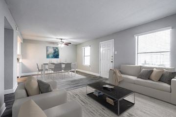 Dallas townhouse for rent - A living room with a grey couch, a coffee table, and a dining table set up.