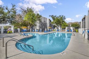 Austin apartment for rent - A large swimming pool with a metal ladder on the side.