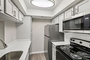 Charlotte apartment for rent - A kitchen with a black stove top oven and a black microwave above it.