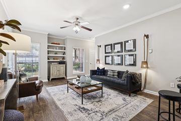 Houston apartment for rent - A living room with a black couch and a ceiling fan.