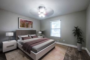 Dallas townhouse for rent - A bedroom with a large bed and a painting on the wall.