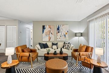 Nashville apartment for rent - A living room with a large painting on the wall and a striped rug on the floor.