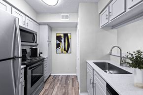Irving apartment for rent - a renovated kitchen with white cabinets and stainless steel appliances
