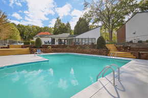 Charlotte apartment for rent - A swimming pool with a diving board and steps leading to a house.