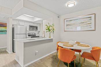 A dining room and kitchen with a table and chairs