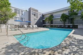 Valley Village apartment for rent - A swimming pool in front of a building with a blue umbrella.