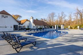 Nashville apartment for rent - A pool with sun loungers and a white building in the background. at The Grove Brentwood, Nashville, TN 37211