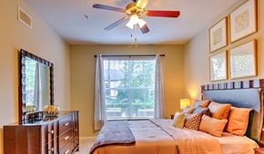 Houston apartment for rent - a bedroom with a large bed and a ceiling fan at Stone Creek at Old Farm Apartments, Texas
